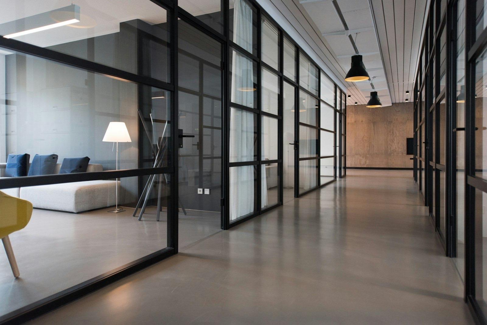 Executive office interior with black-framed glass partitions and lounge seating