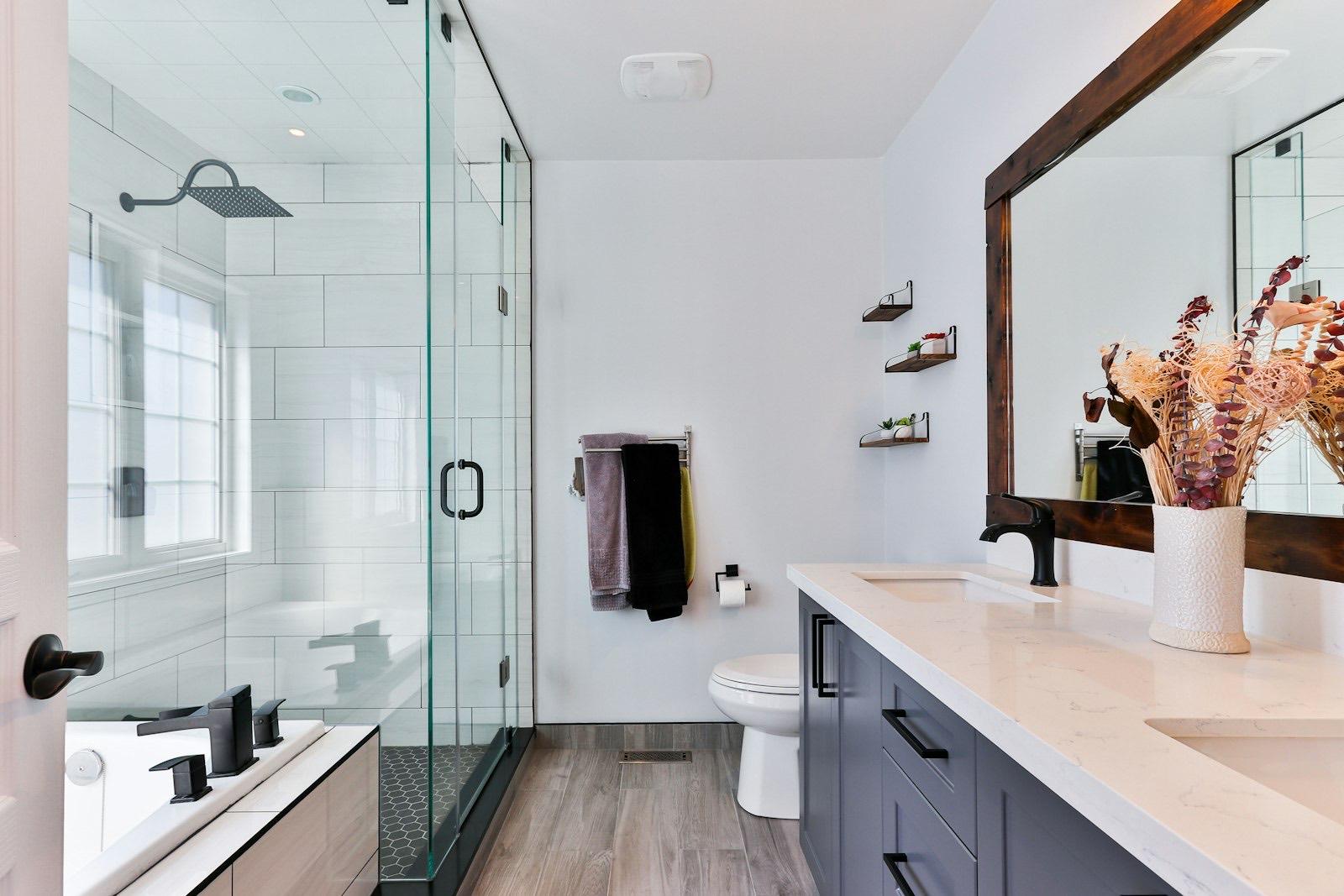 Luxury bathroom with frameless glass shower, timber-framed mirror and stone vanity